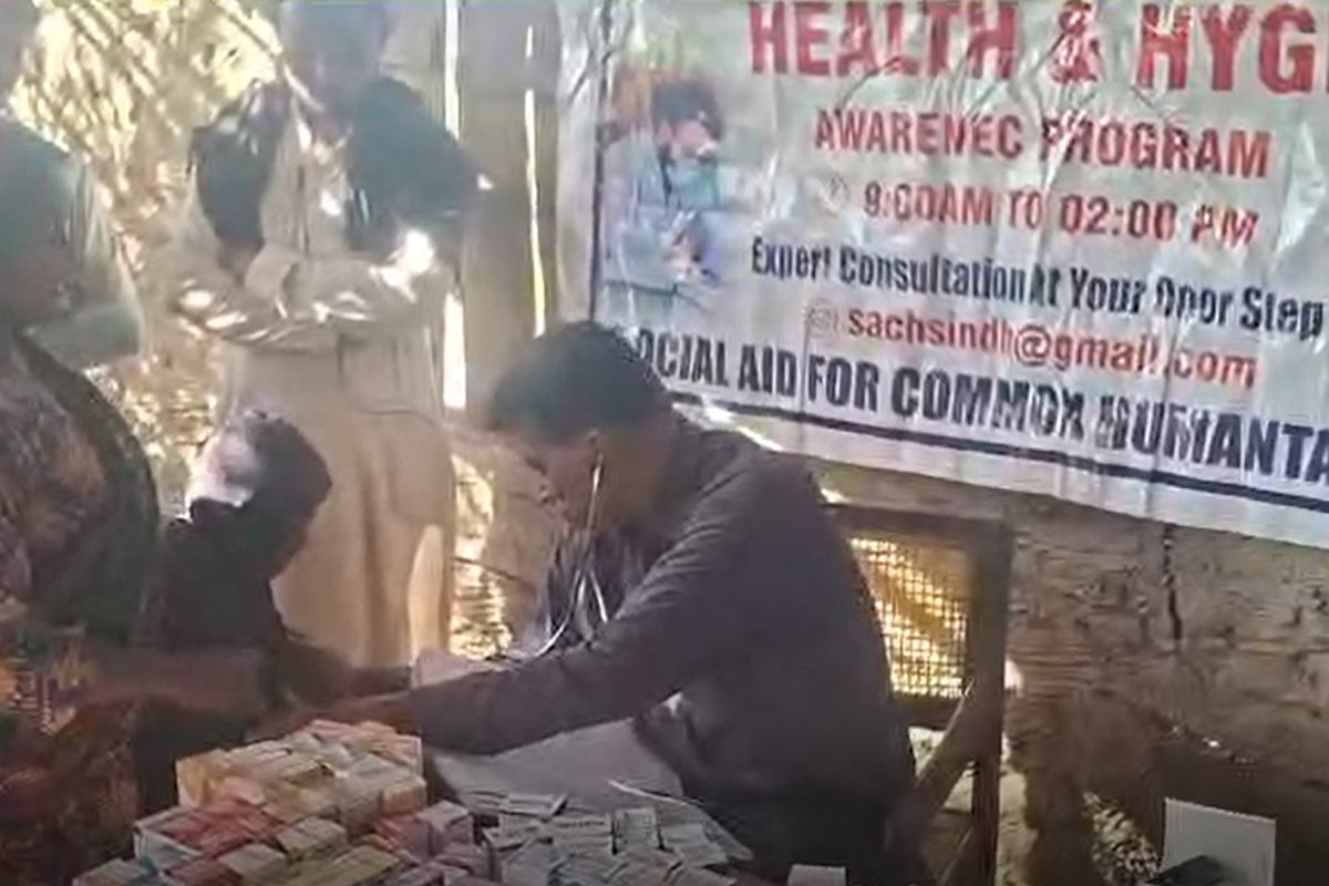 A doctor examining a patient at a free SACH medical camp in a rural village
